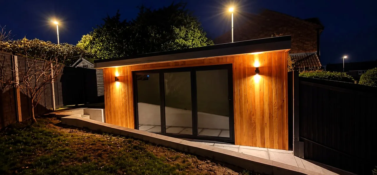 Illuminated timber garden room at dusk