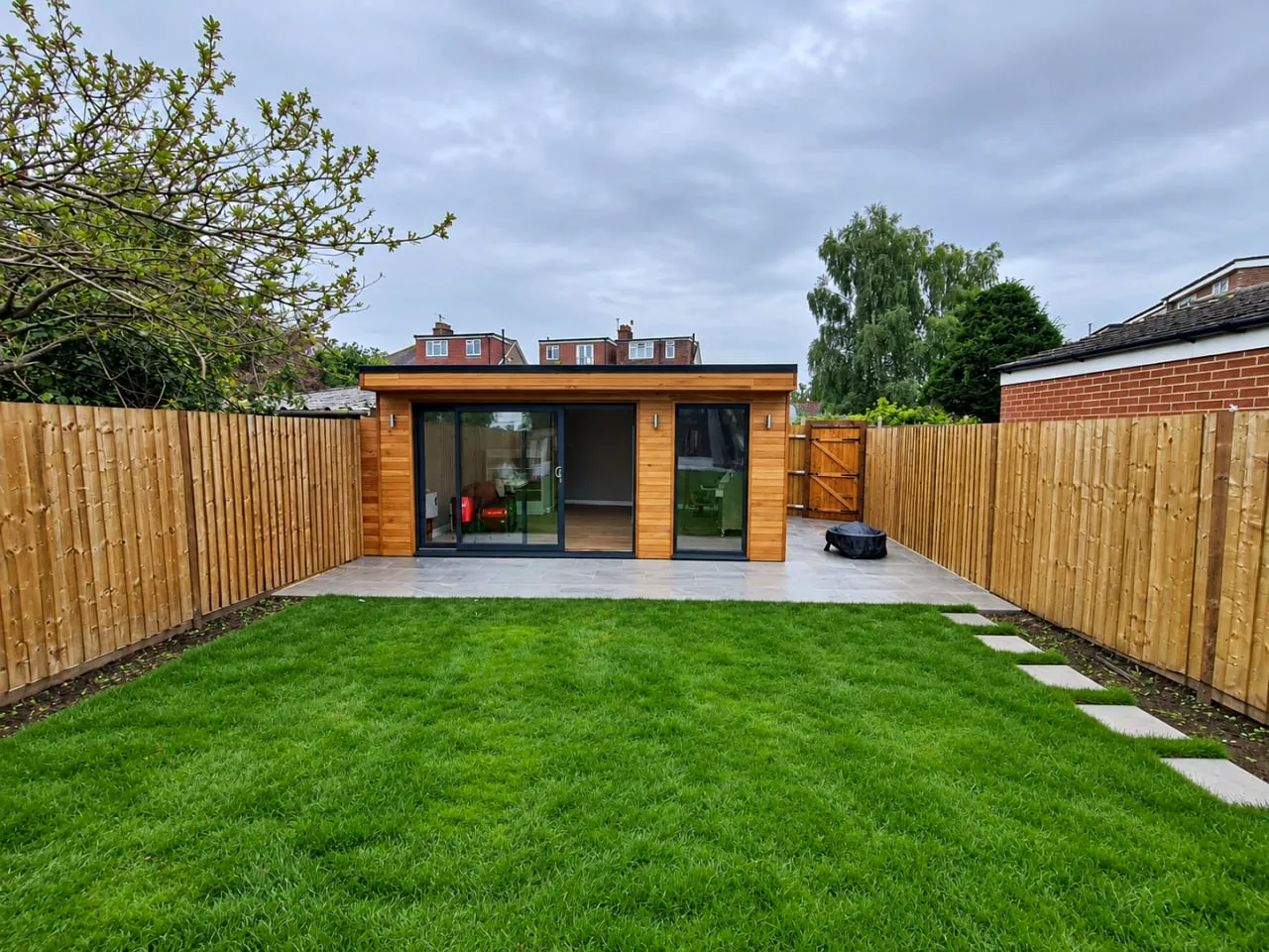 Garden room seen across a lawn and new fencing